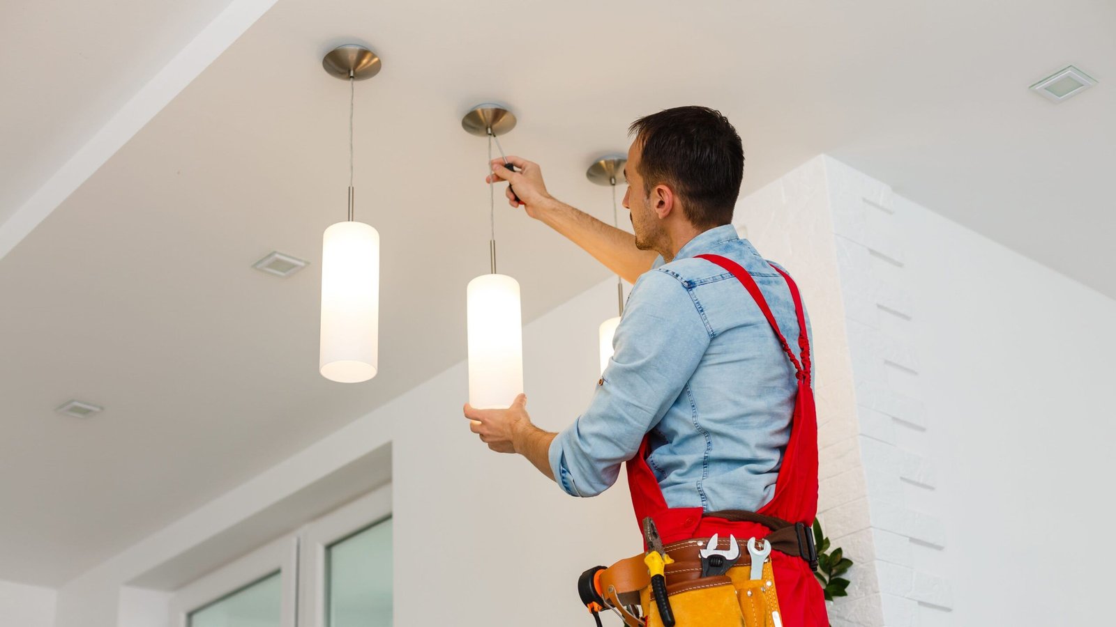 Technician adjusting an indoor lighting fixture